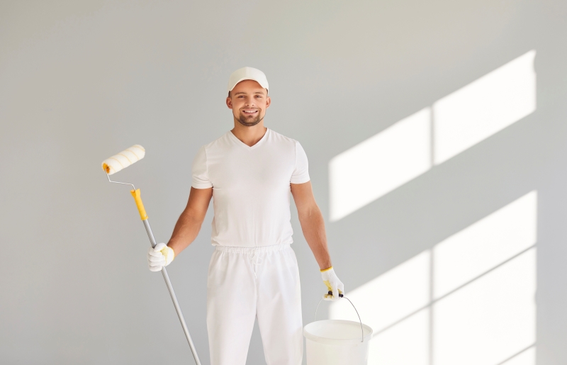 Smiling male painter in a white uniform