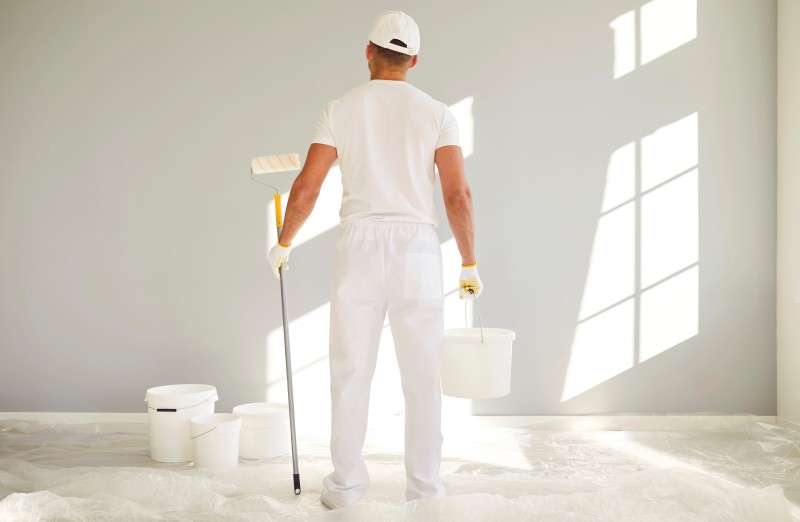 Back View Male Painter White Uniform Bucket Paint Roller Hands Going P